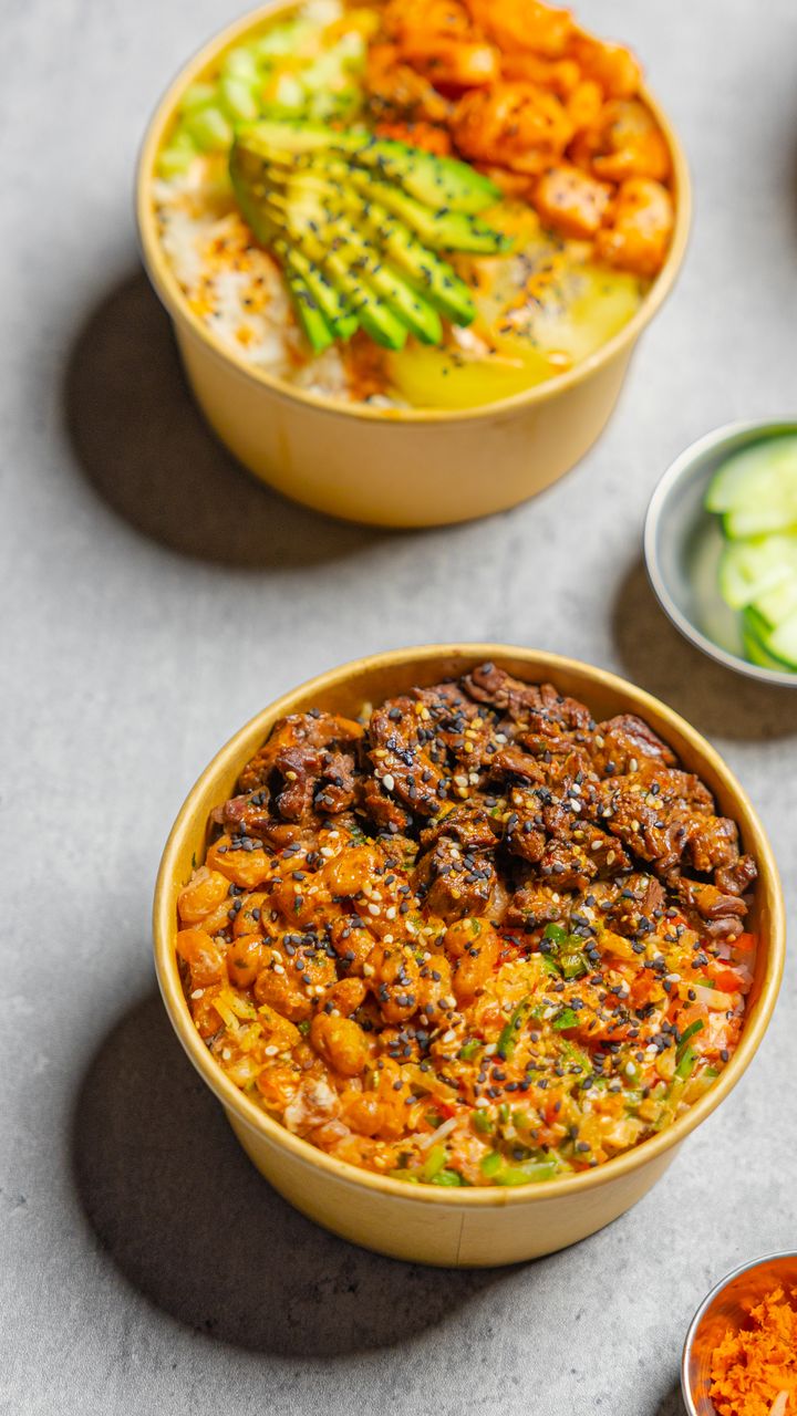 Poke bowls de Poke to Go vistos desde arriba: uno con aguacate en abanico y otro de arrachera